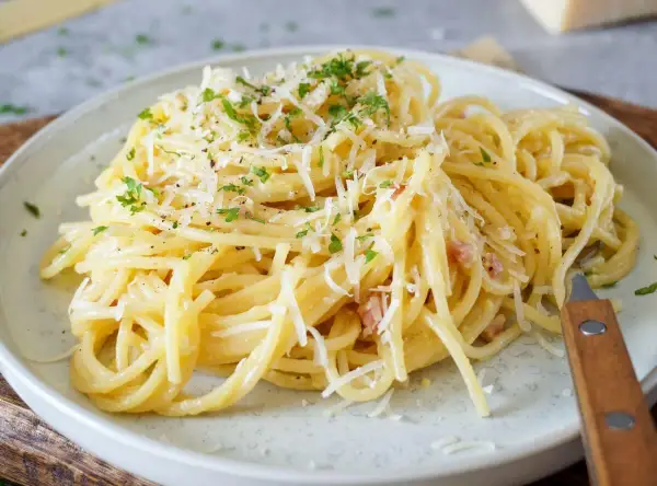 Spaghetti Carbonara, cremig und mit viel Parmesan bestreut. Ob mit nur Eigelb oder ganzem Ei, diese Carbonara ist ein Genuss.